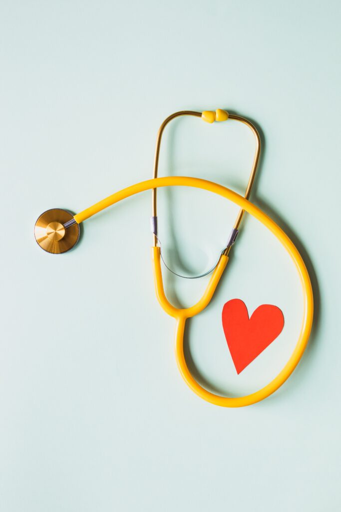A stethoscope with a heart on a pale blue background