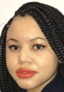 A close-up selfie of Simone, a black woman with red lipstick, cat-eye makeup, and long braids. 